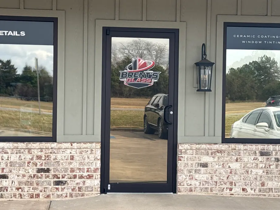 Glass door of Suite D with the Brent's Glass logo decal and a window tinting sign