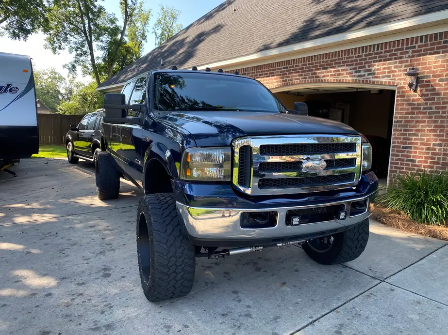 Lifted navy Ford F-250 parked on a customer's driveway